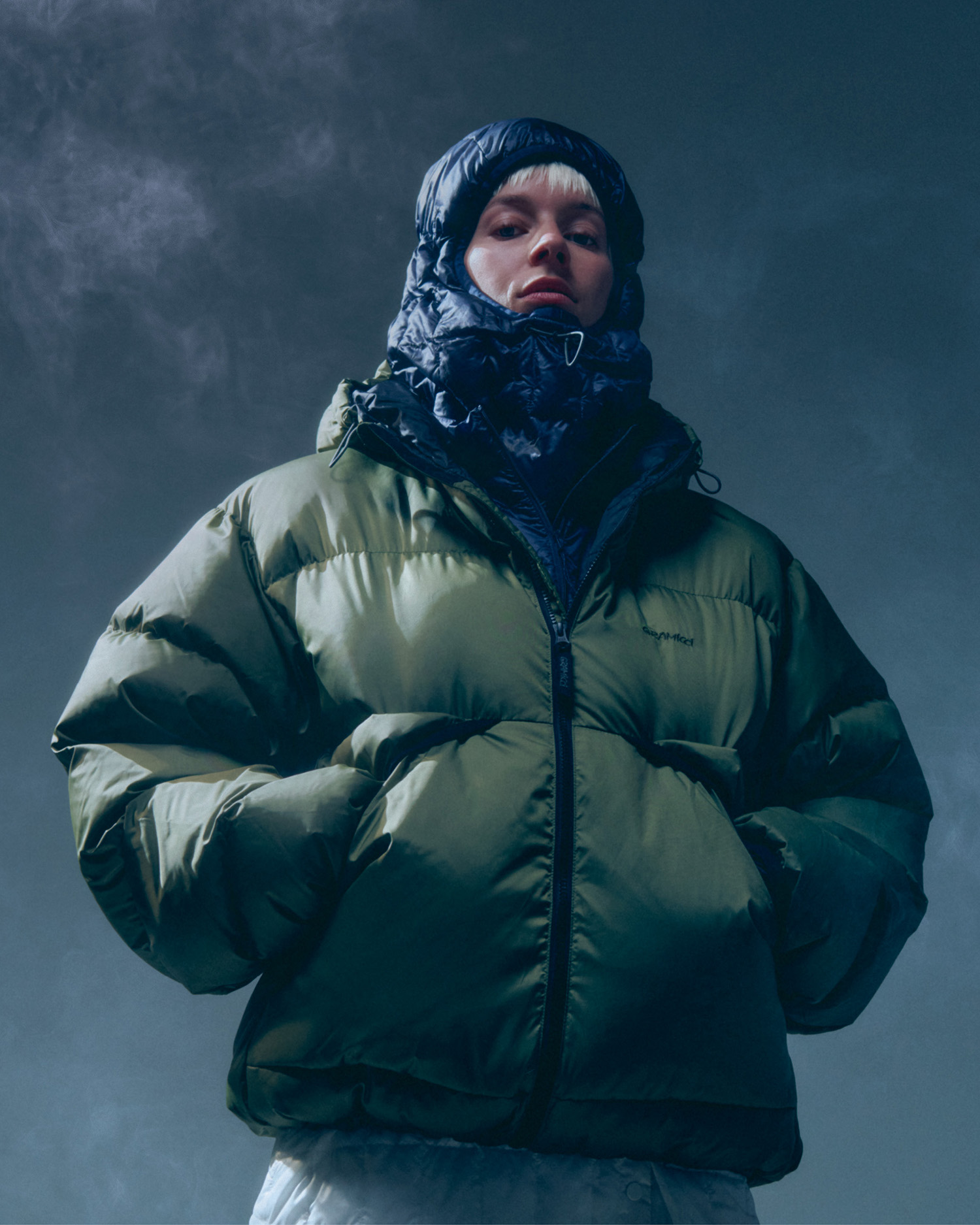 冬の霧の中に立つ、オリーブのColdfront Down Jacketを着たモデル