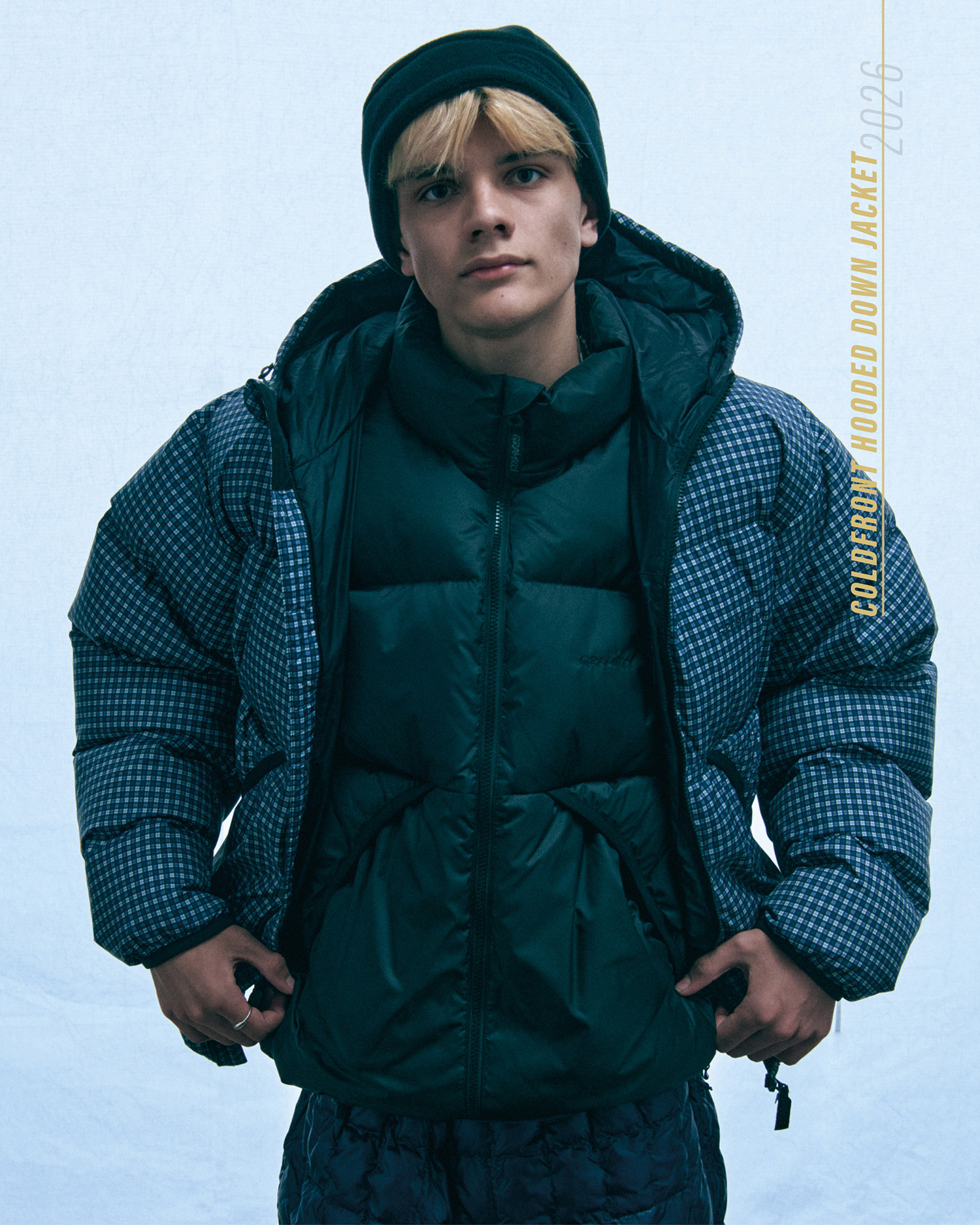 ダークグリーンのダウンジャケットにチェック柄のColdfront Down Jacketを重ねたスタイル